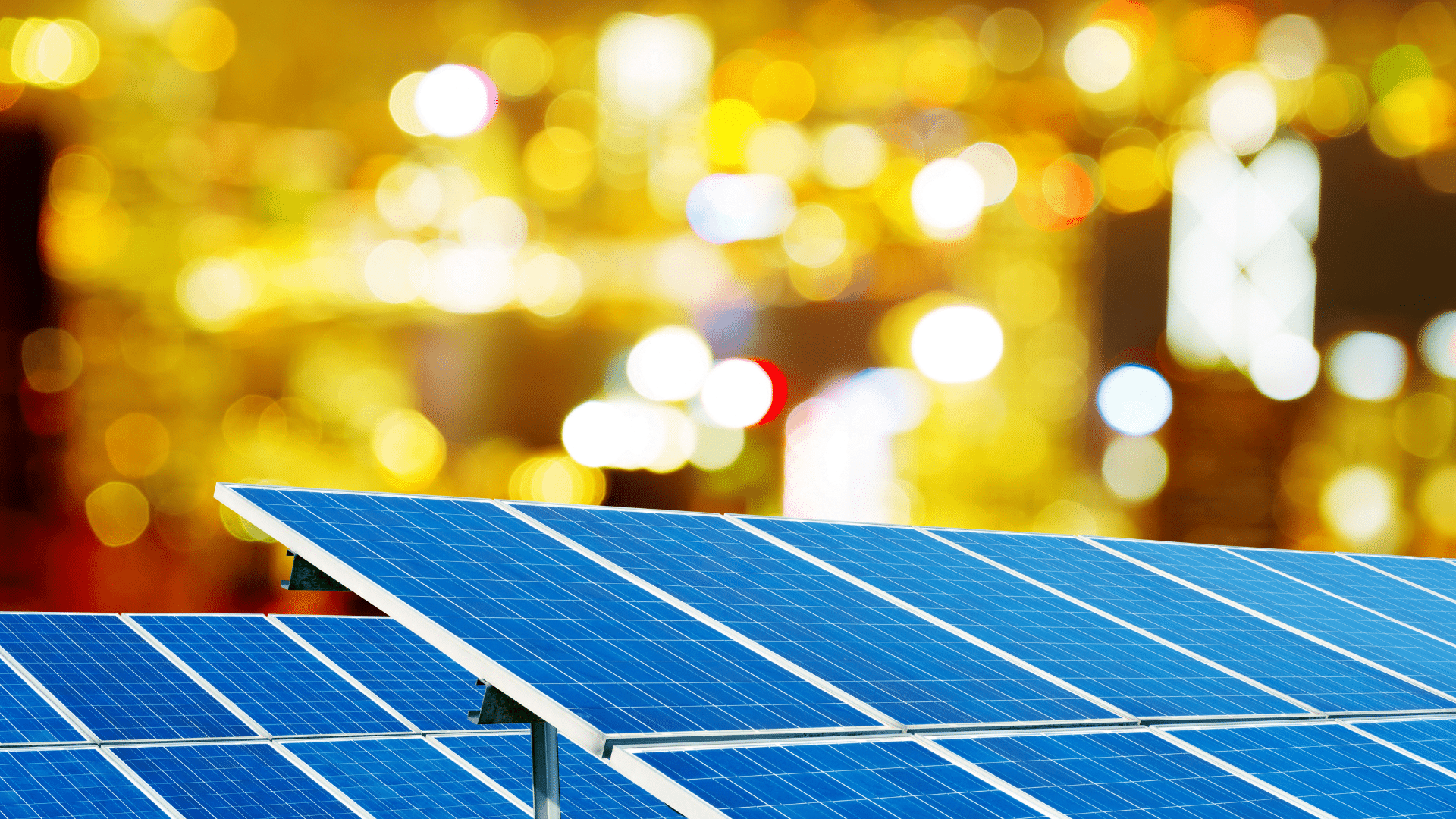 Pannelli fotovoltaici in primo piano con sfondo di luci sfocate della città. Incentivi fotovoltaico per le imprese