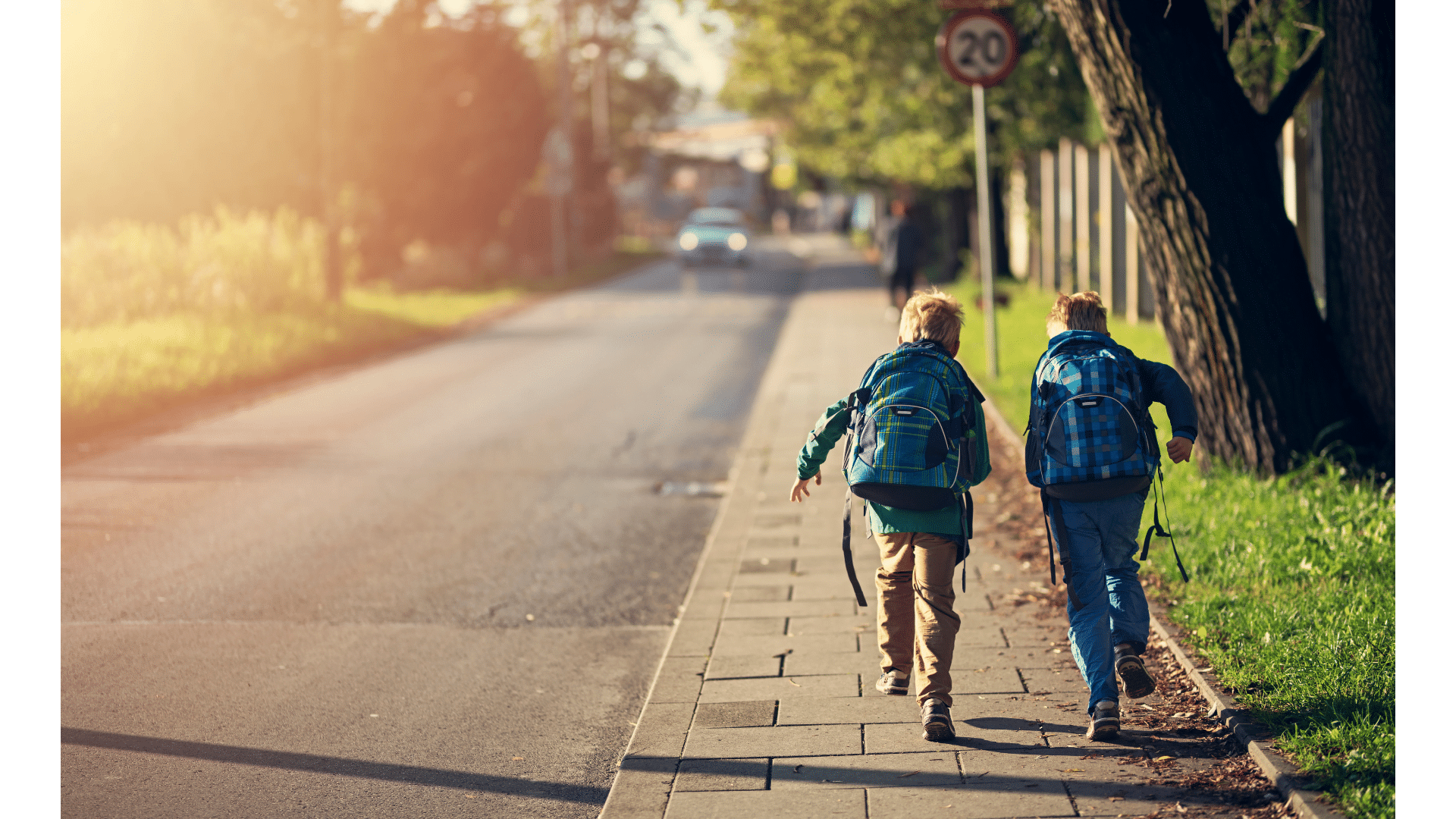 Bambini che vanno a scuola che corrono su marciapiede di strada pubblica, con cartello stradale. Spazio verde e auto che percorre la strada. Contributi a fondo perduto per interventi di efficientamento energetico.