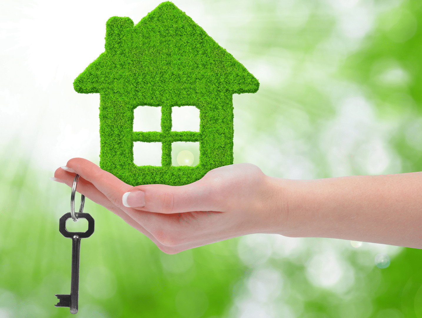 Casa verde appoggiata su una mano con una chiave. Case green: stop vendita abitazioni energivore